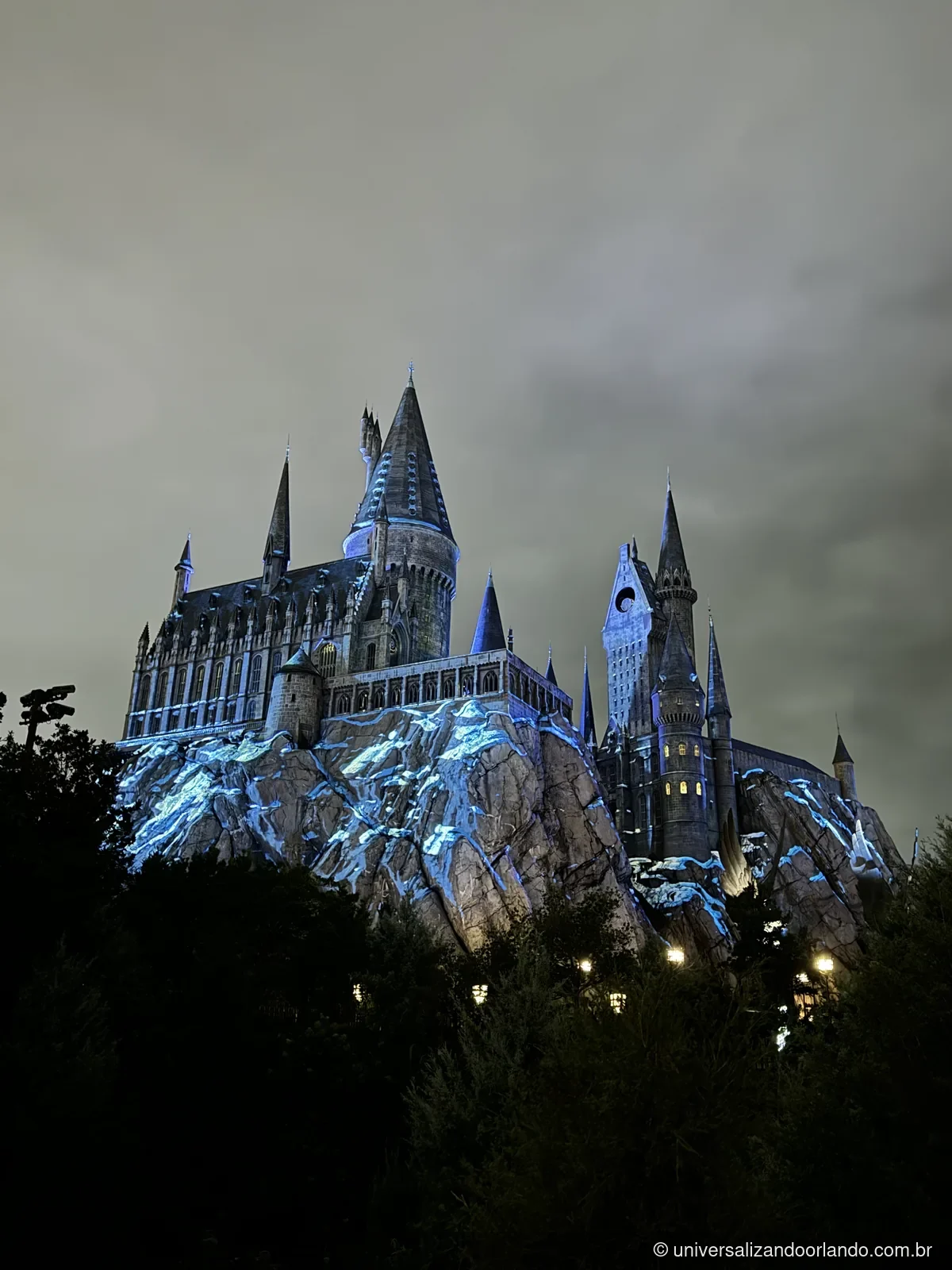 Castelo de Hogwarts com projeção azul durante a noite
