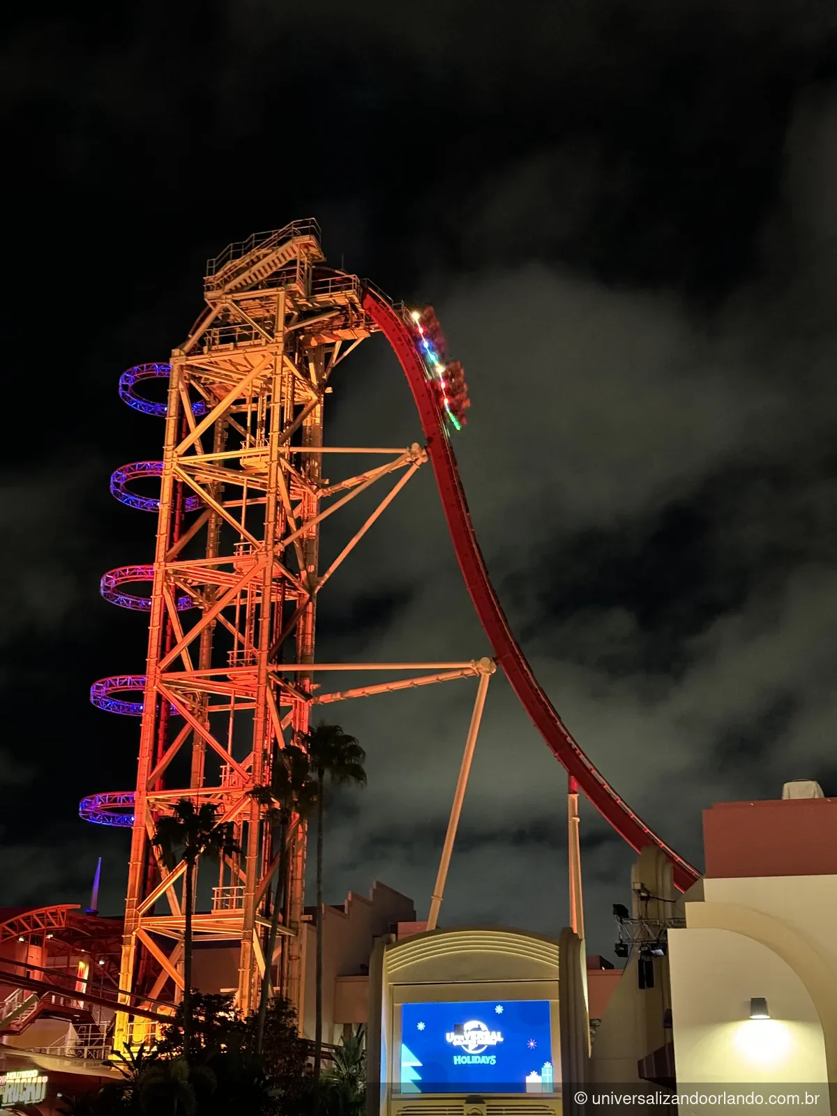 Montanha-russa Rip Ride Rockit iluminada de laranja à noite