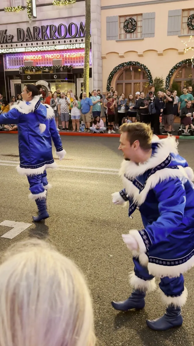Bailarinos com figurino azul e branco dançando no desfile de Natal da Universal
